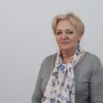 Kobieta blond w szarej bluzce i kolorowej apaszce
